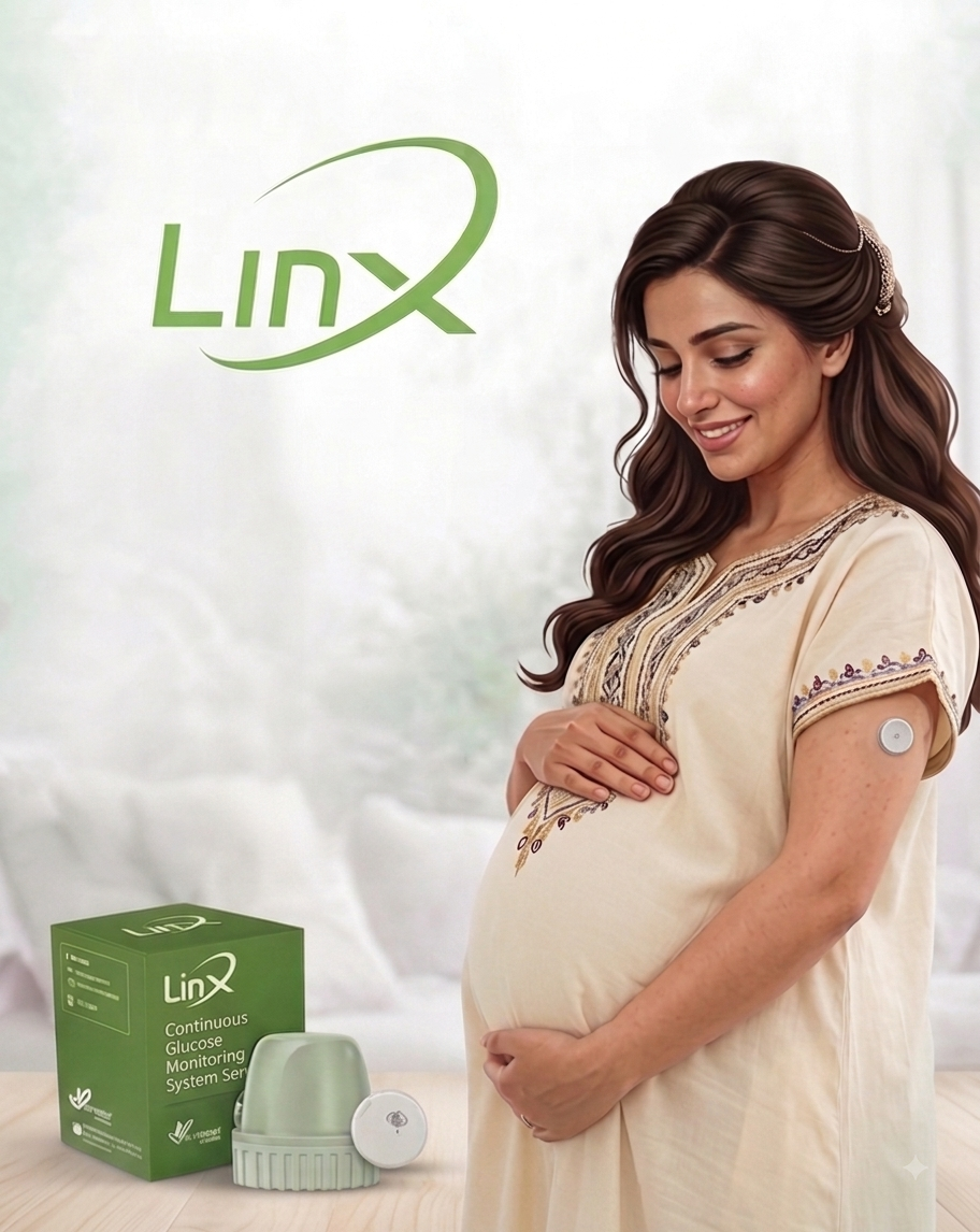 A smiling pregnant Omani woman with a Continuous Glucose Monitor (CGM) linx sensor sits on her upper arm